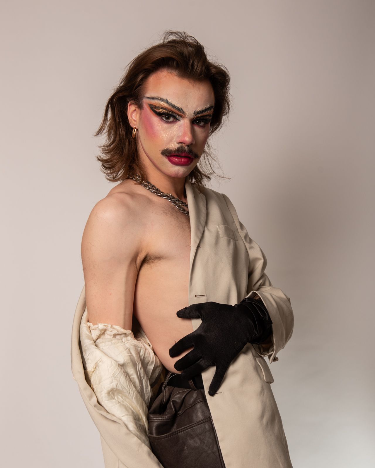 Fashion model in dramatic black and white contrasting outfit with bold makeup and gloves striking editorial poses.