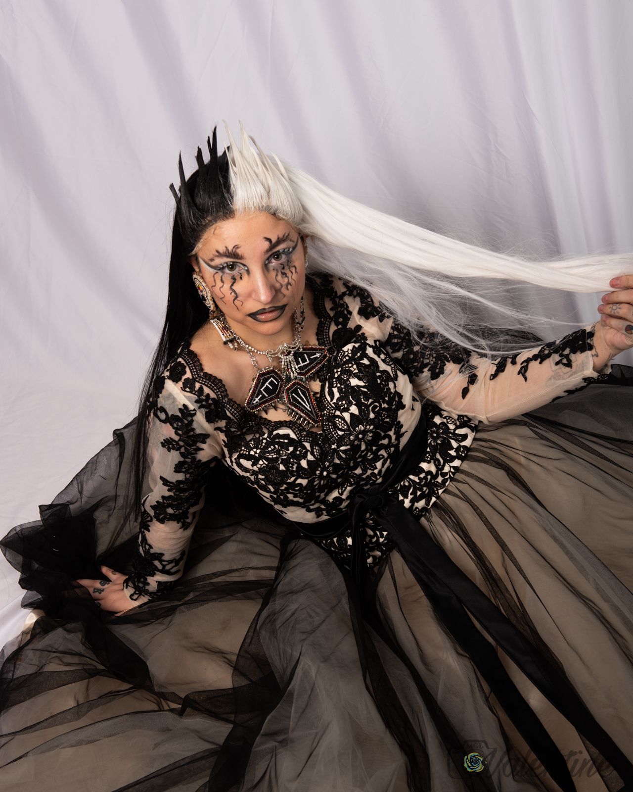 A fashion photo series showing a model in a dramatic black lace and gray gown against a light backdrop.