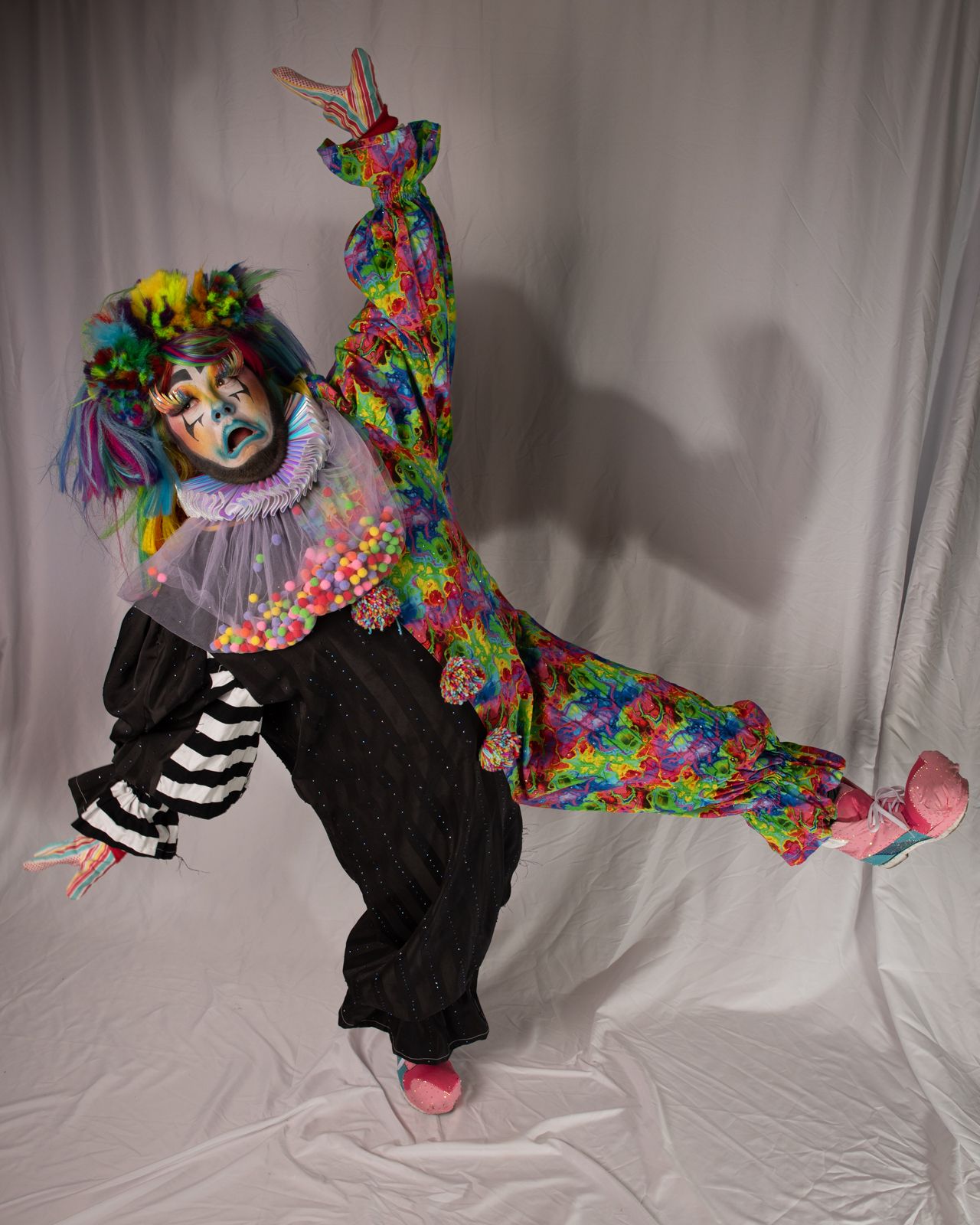 A sequence of dance poses showing a person in a black and colorful floral costume performing dynamic movements.