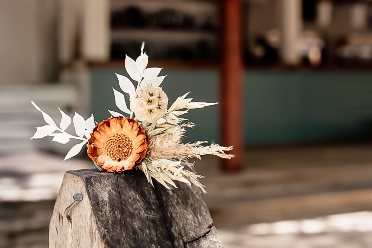 Rustic stone decor elements adorned with dried flowers and white blooms in natural outdoor setting.