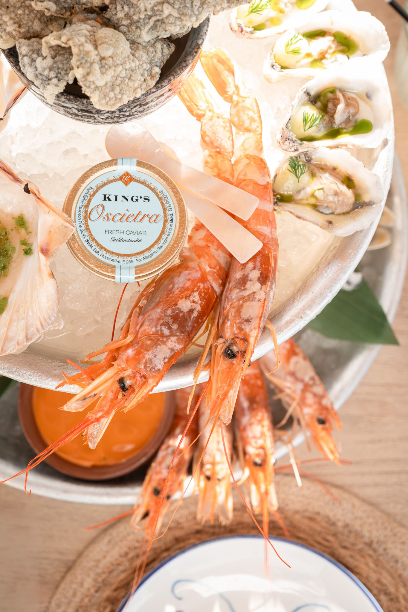 Fresh prawns and seafood served with King's Cuisine sauce in an elegant table setting.