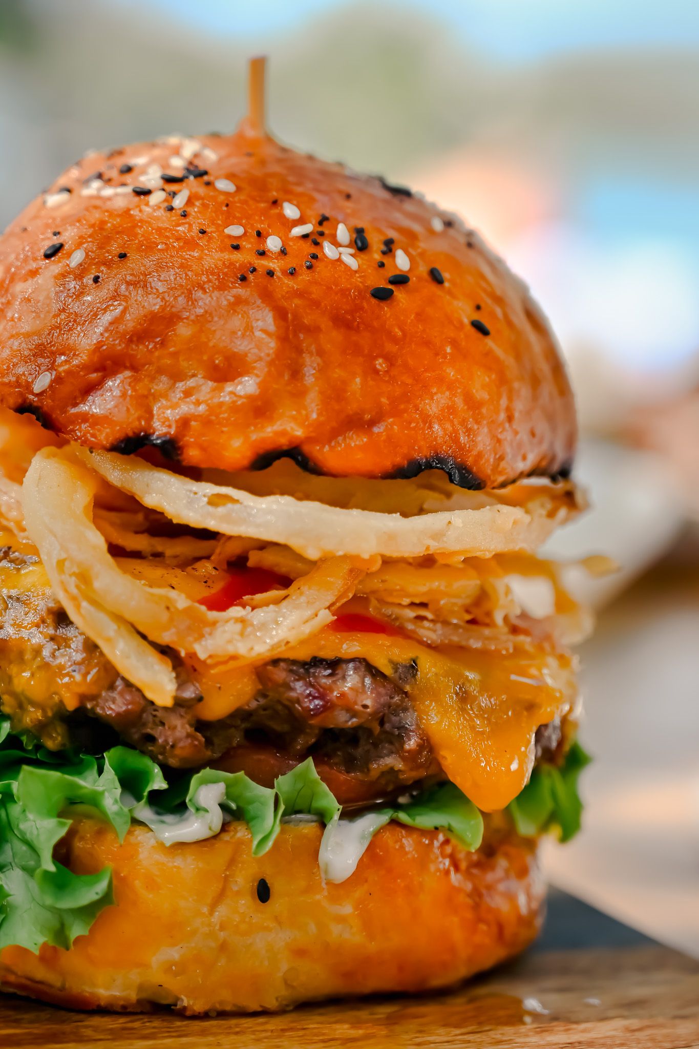 Close-up sequence of juicy gourmet burgers with melted cheese, fresh lettuce and sesame seed buns.
