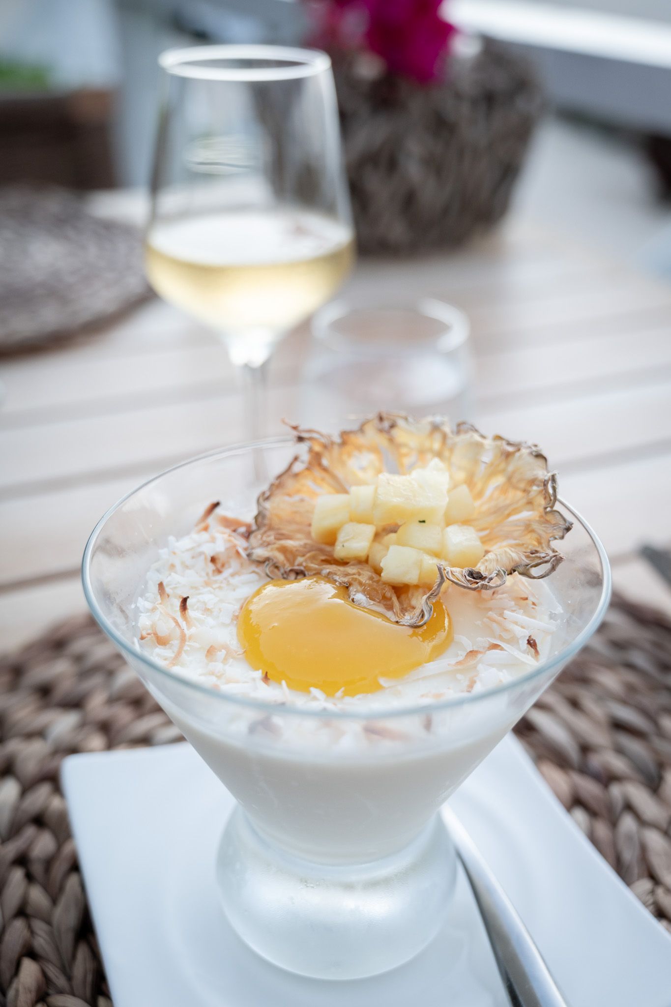 Tropical coconut dessert with fresh pineapple and toasted coconut flakes served in elegant glass bowls.