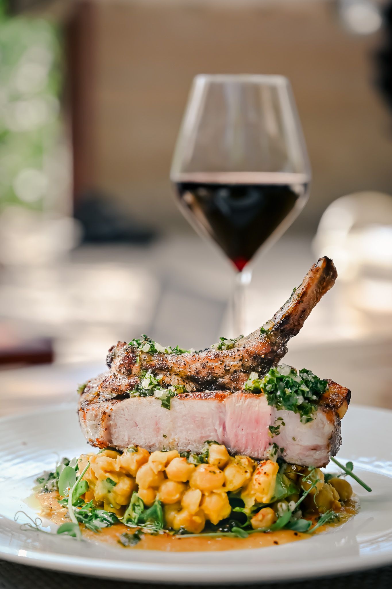 Grilled pork chops served on white plates with colorful garnish and sweet potato mash.