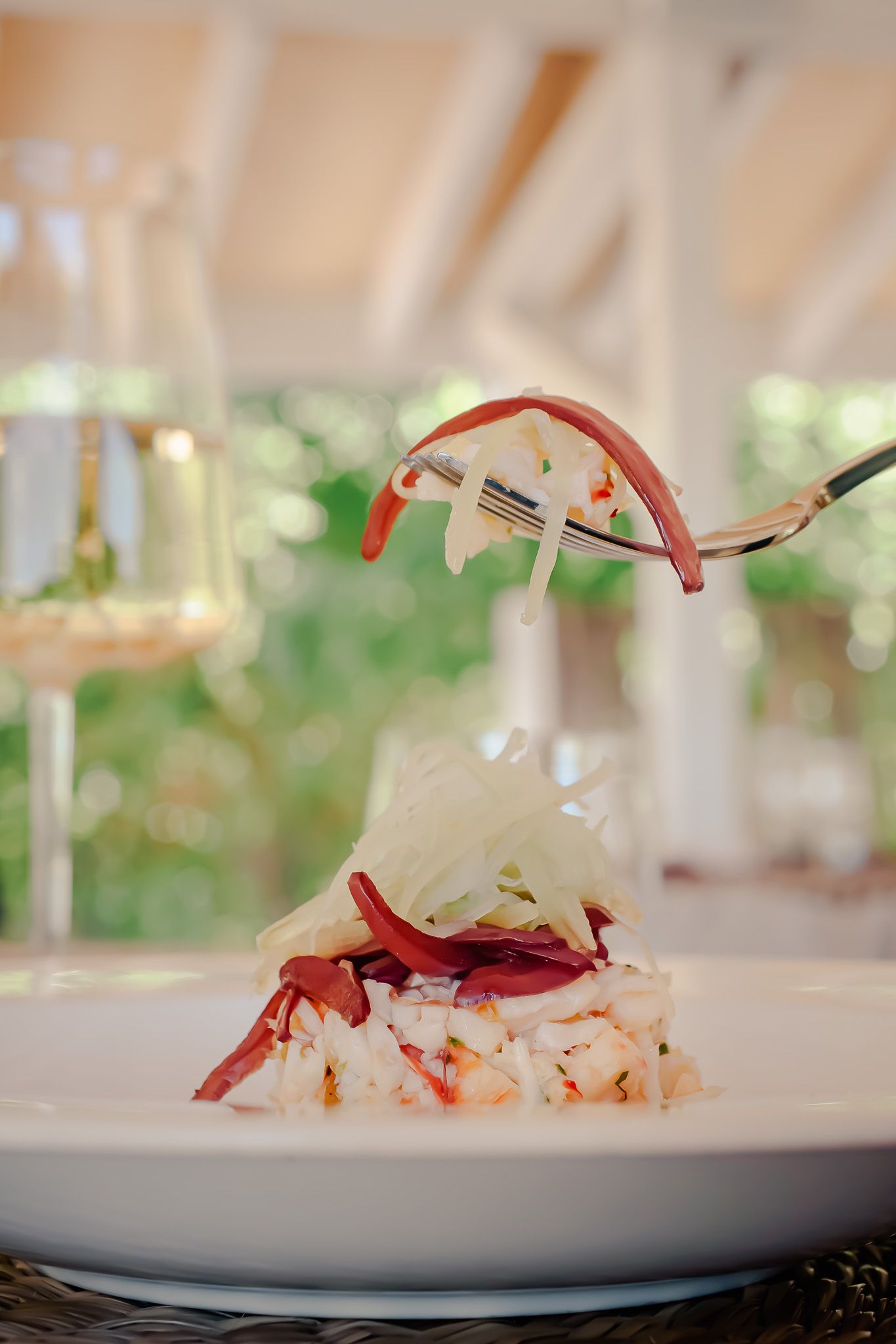 Close-up view of an elegant seafood appetizer with shrimp and white garnish on a pristine white plate.