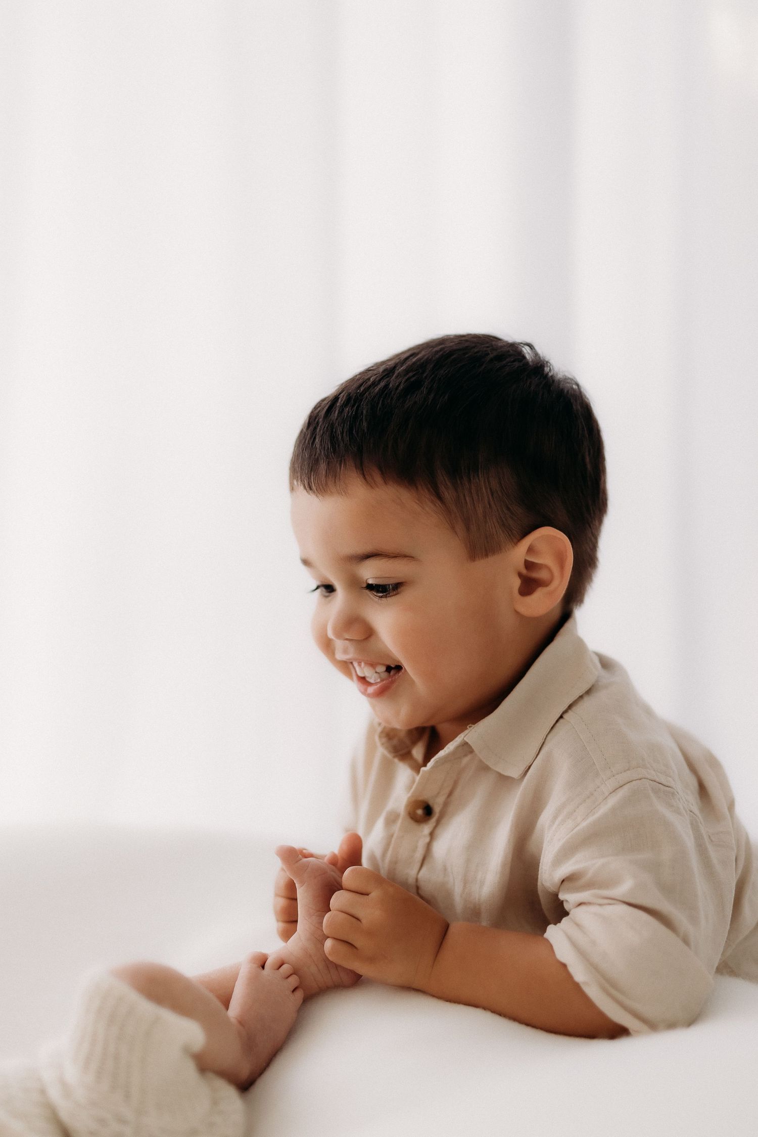 Child photographed against neutral backdrop in modern photography studio