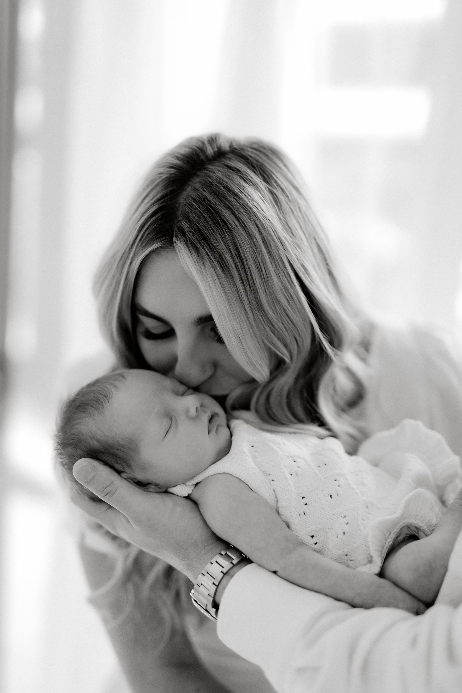Parents holding newborn baby during modern studio photography session on Sunshine Coast