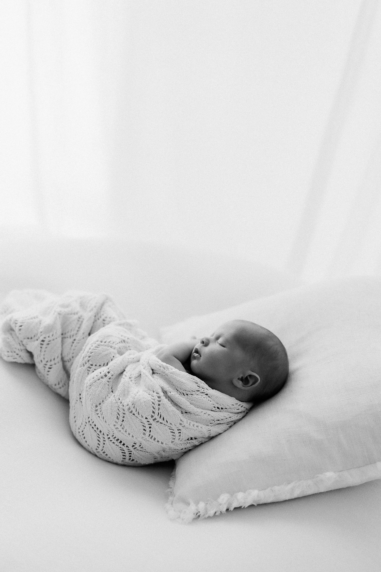 Parents holding newborn baby during modern studio photography session on Sunshine Coast