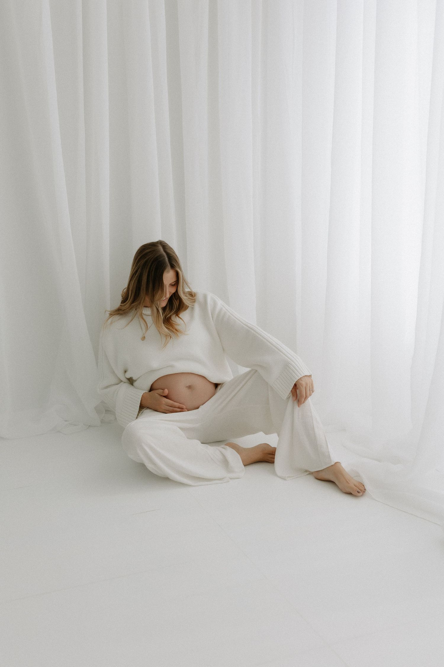 Pregnant mother photographed in neutral editorial studio setup