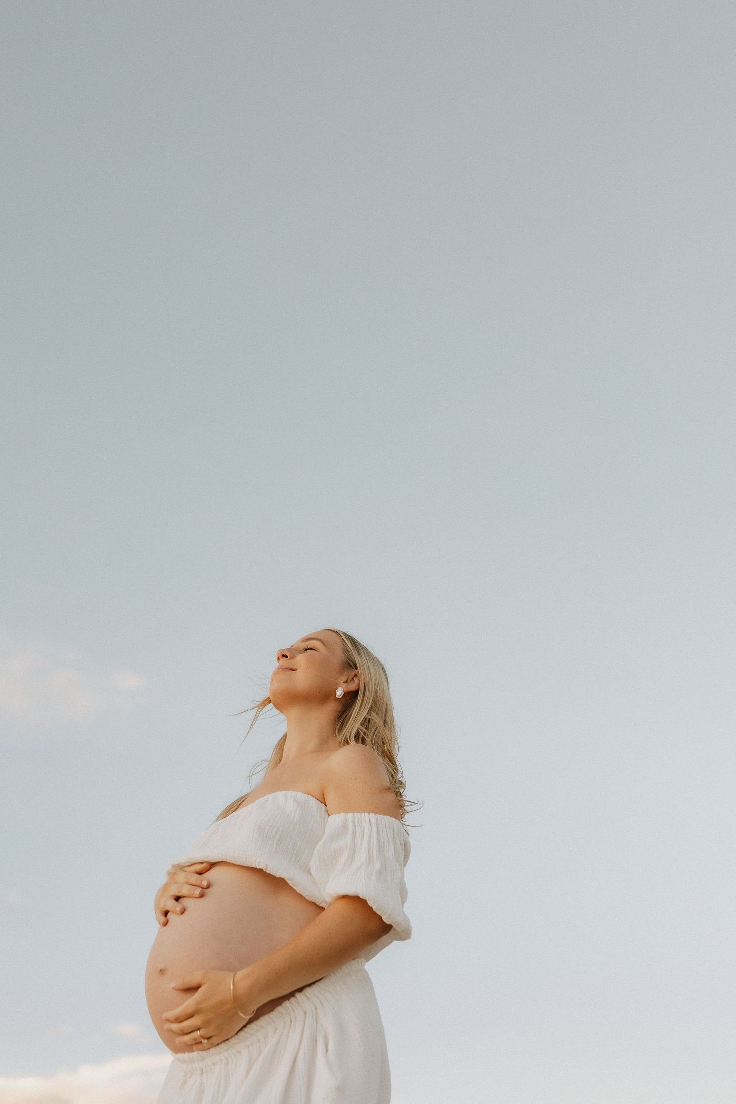 Mum cuddling her newborn baby in natural light photography studio in Peregian Beach
