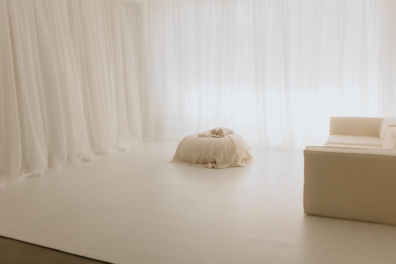 Editorial newborn portrait with soft cream styling and neutral tones