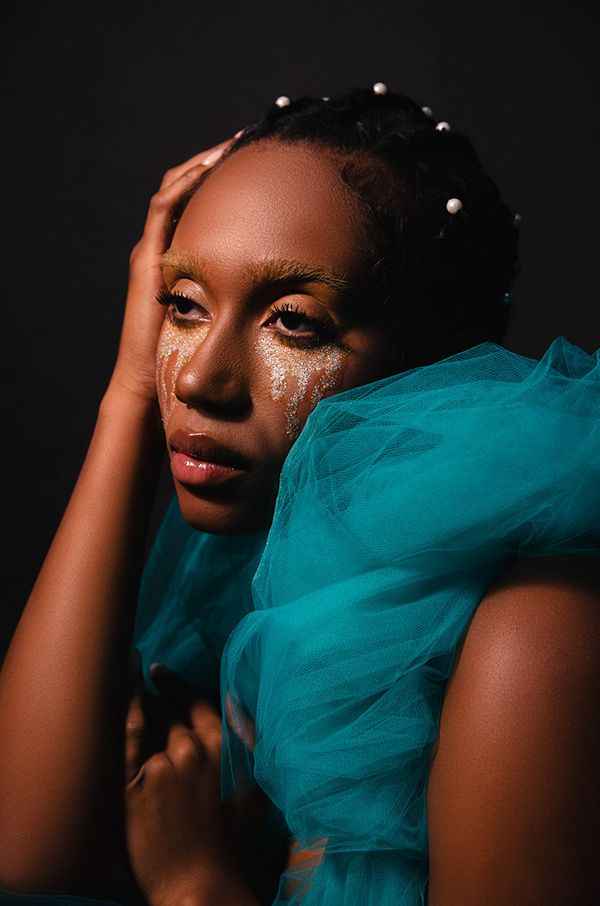 editorial photoshoot of a sad girl crying glitter