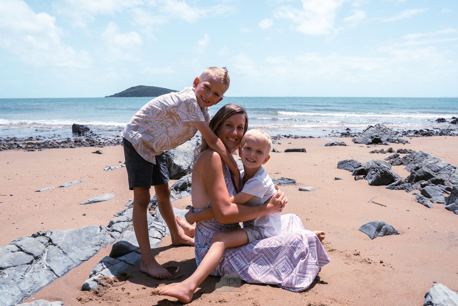 A series of beach photos showing a couple enjoying time together on a sandy shoreline with waves and rocks.