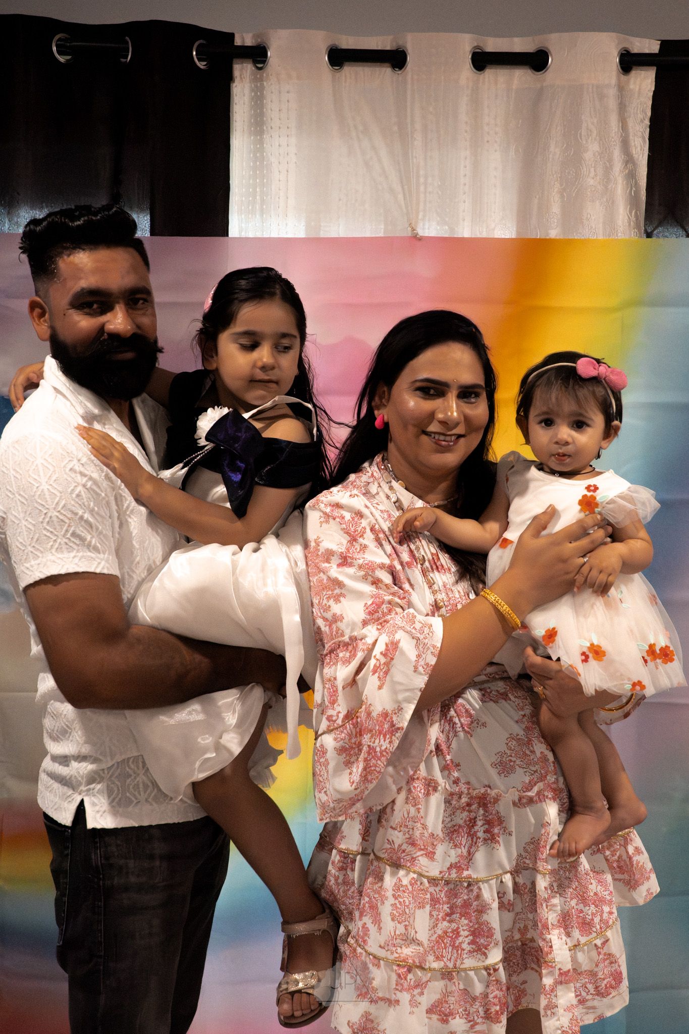 A series of photos showing adults dancing and holding children at an indoor event with colorful lighting.
