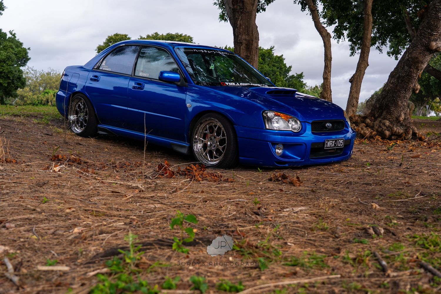 Blue Subaru WRX STI sports car photographed in multiple views against a natural outdoor setting.