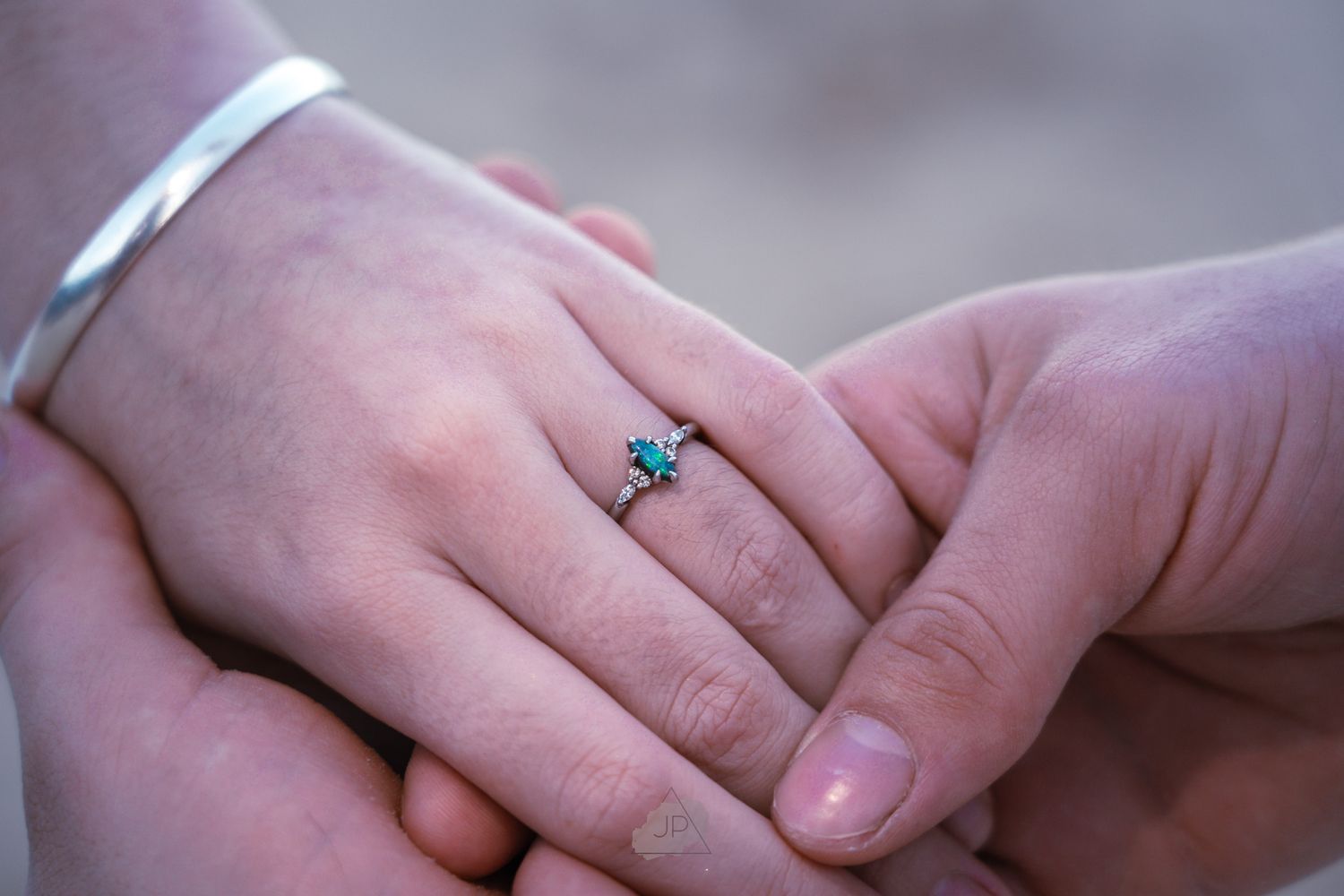 A close-up sequence of hands exchanging a turquoise ring during an engagement or wedding proposal.