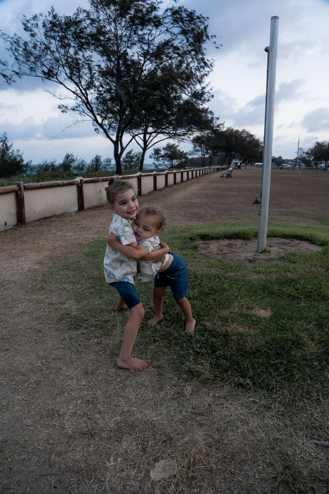 A sequence of three photos showing someone climbing and playing on a metal pole in a grassy outdoor area.
