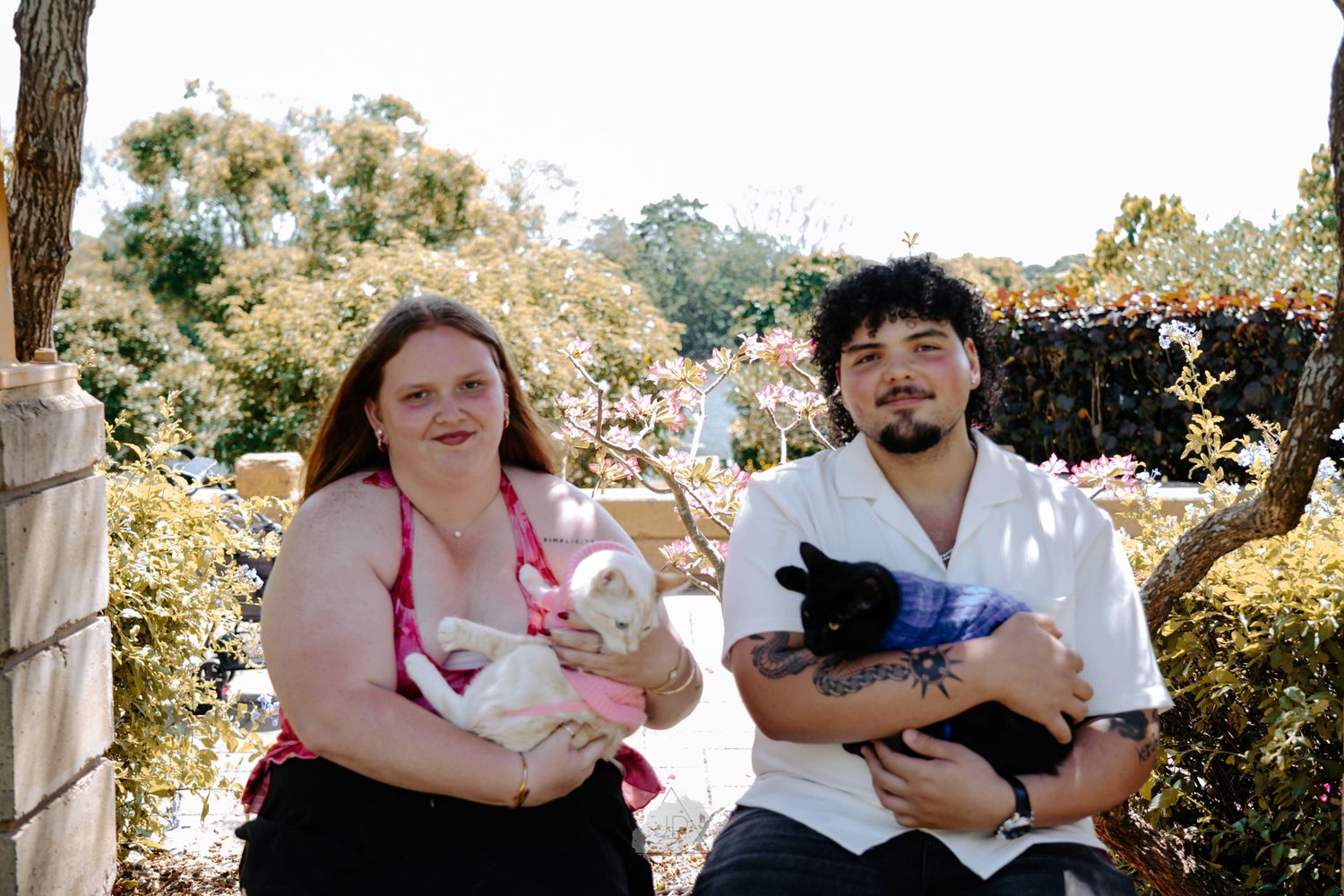 A group of people gathered outdoors enjoying a sunny day in a garden setting.