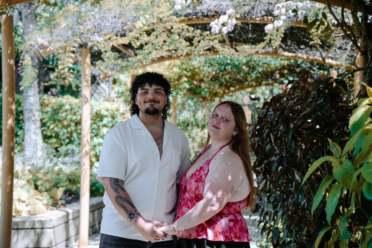 Couple shares romantic moments in a garden setting during their wedding photo session.