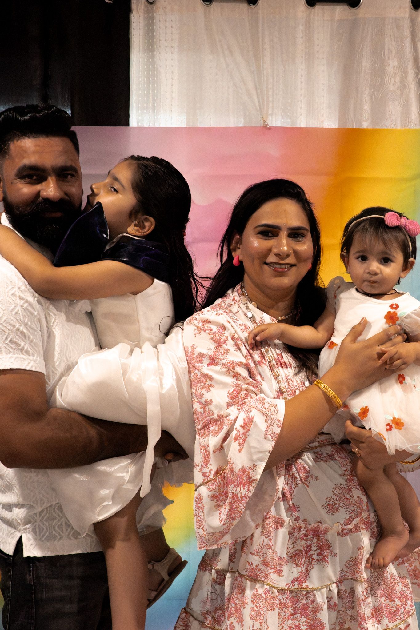 Multiple snapshots of people dancing and holding children at a festive indoor celebration.