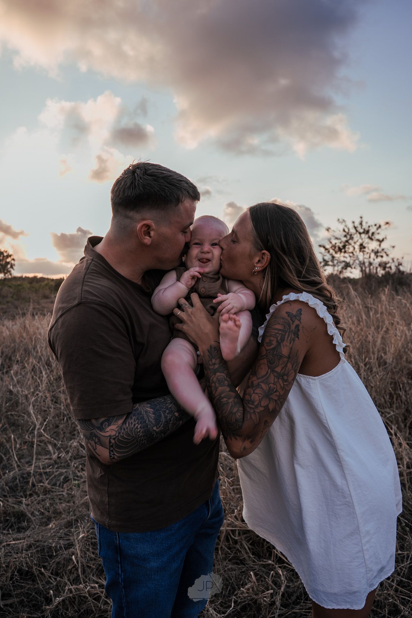 A loving family shares tender moments together during a sunset photoshoot in a natural outdoor setting.