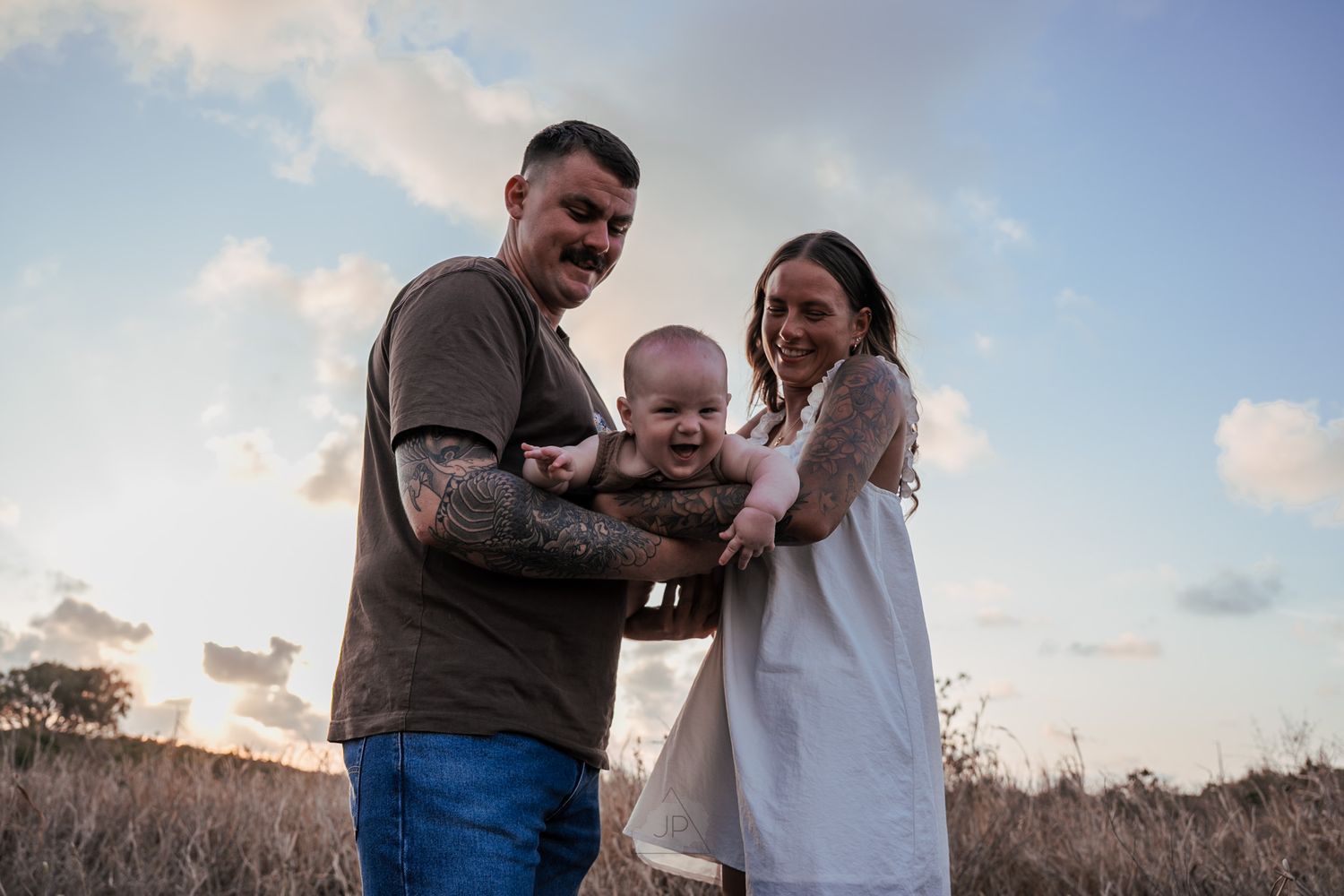 A series of candid outdoor family photos showing joyful moments and interactions at sunset in a grassy field.