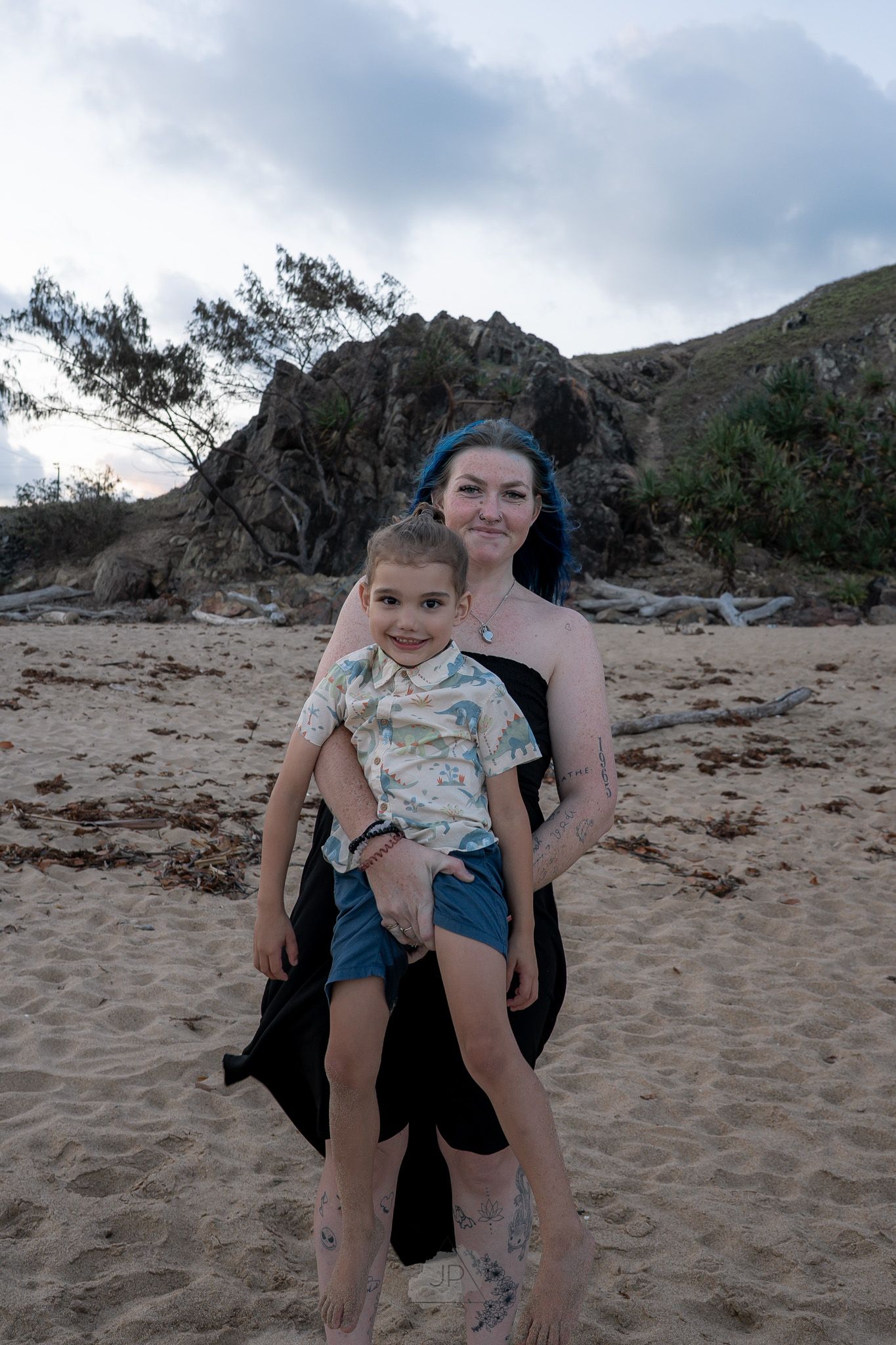 Four sequential photos show a playful moment on a sandy beach with mountains visible in the background.