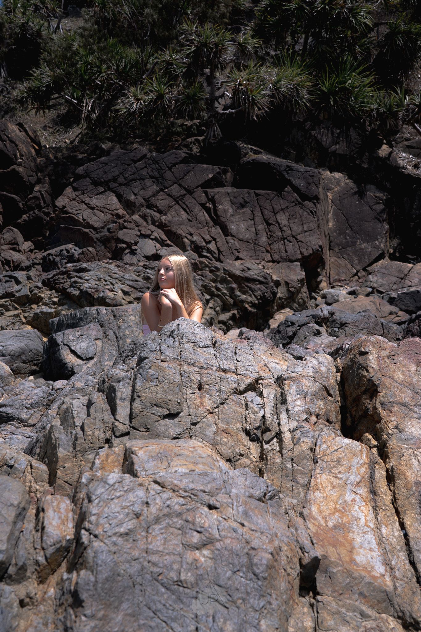 Rock climber ascending a steep granite cliff face in natural sunlight.