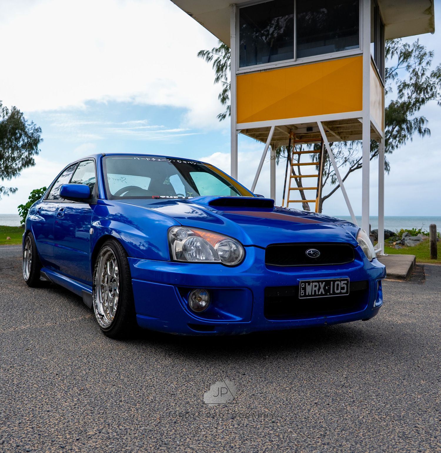 A bright blue Subaru WRX STI sports car shown from multiple angles with custom wheels and lowered suspension.