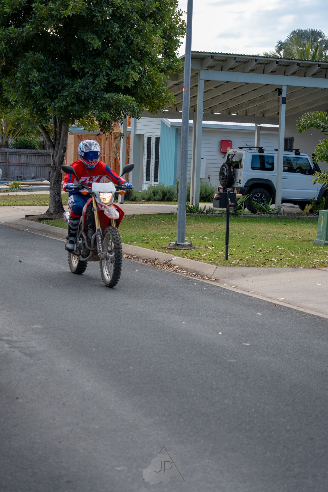 Sequence of motorcycle parking under covered carport spots showing multiple angles of red motorcycle against gray pavement.