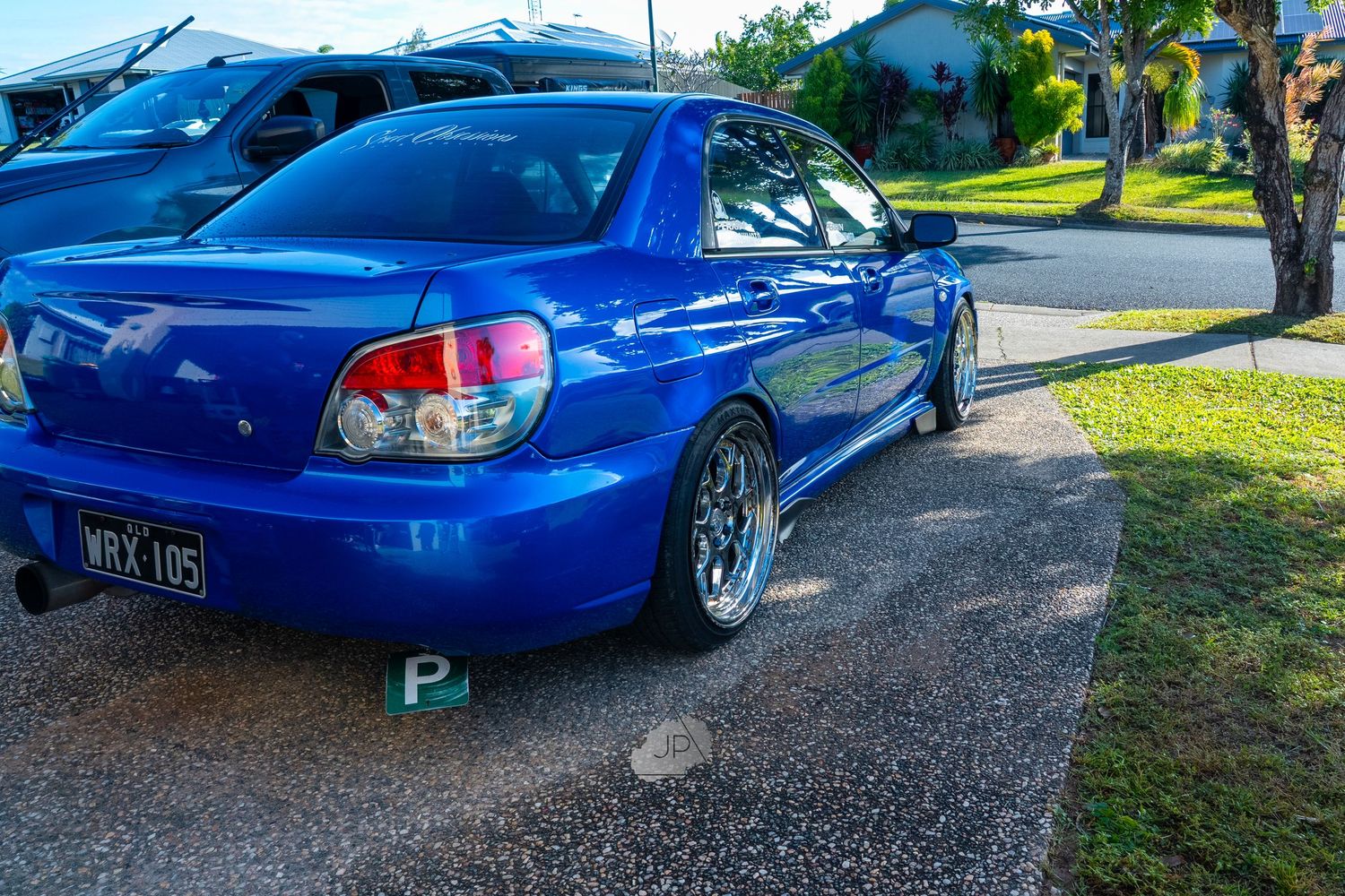 Blue Subaru WRX STI with custom modifications shown from multiple angles in parking lot.