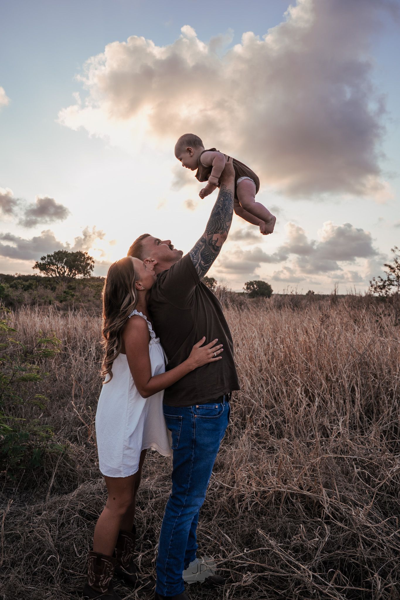 Romantic couple embraces in a golden field at sunset, creating a series of intimate dance-like poses.