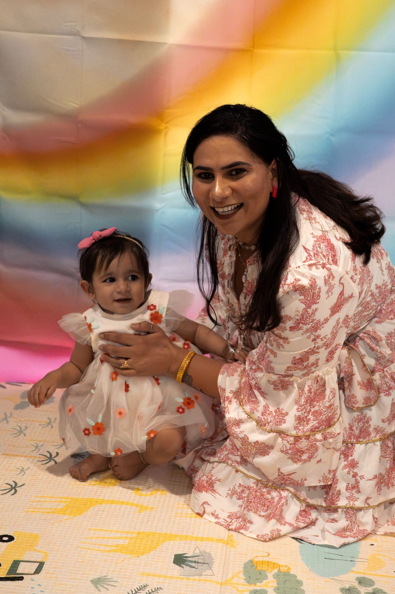 A series of candid photos showing joyful moments between parent and baby against a colorful rainbow background.