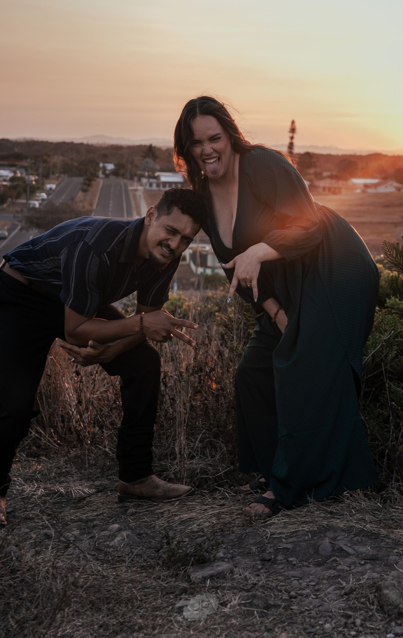 Candid engagement photos of couple playing and laughing together at golden hour.