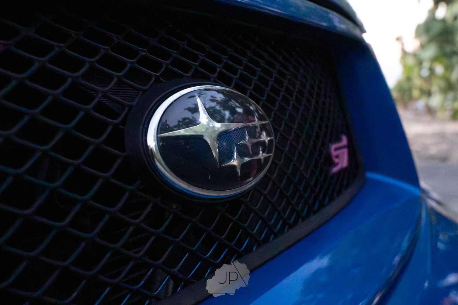 Close-up sequence showing different angles of a blue Subaru car grille and front-end details.