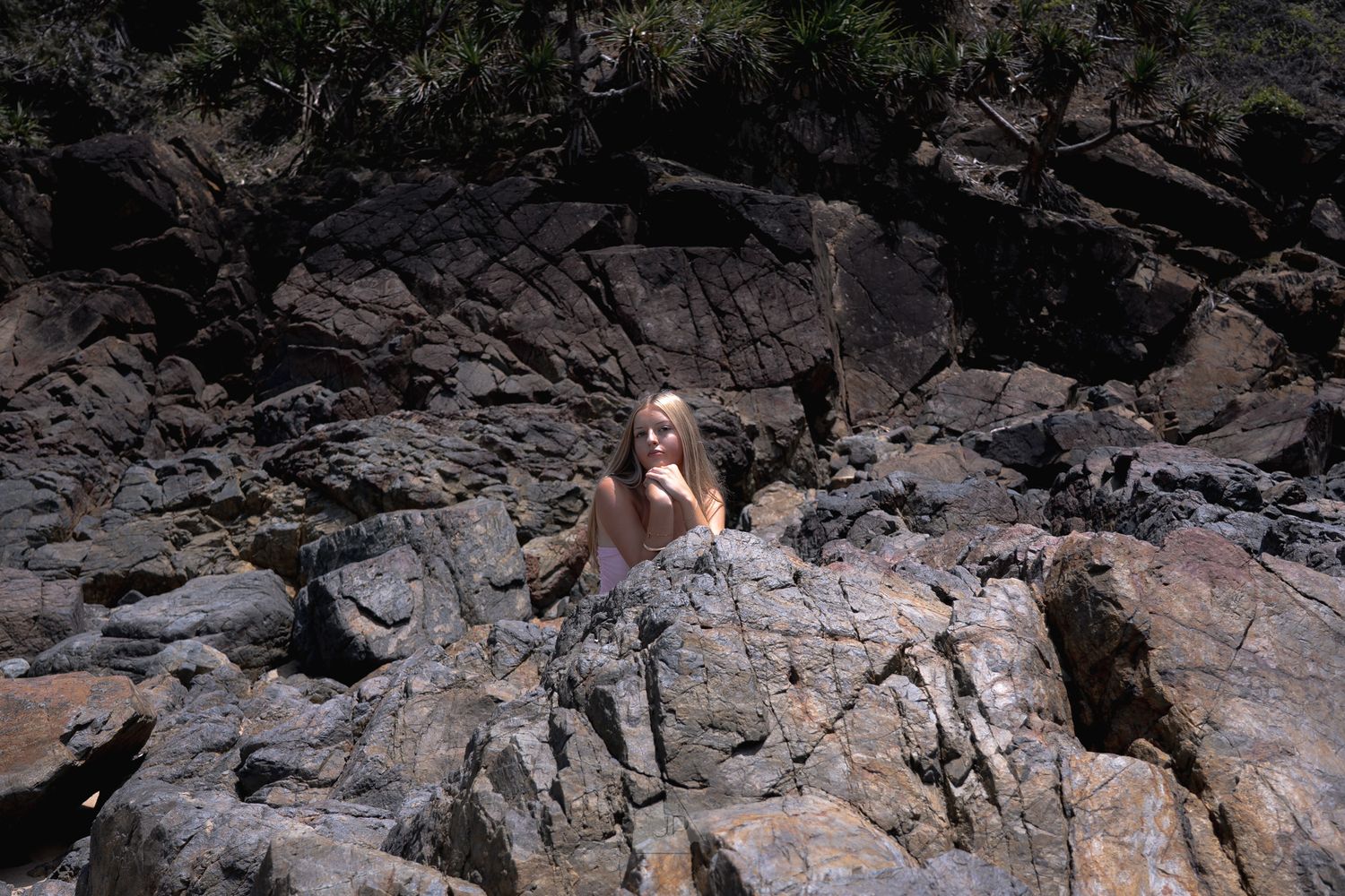 Rock climber navigating a challenging rocky outcrop during an outdoor climbing session.