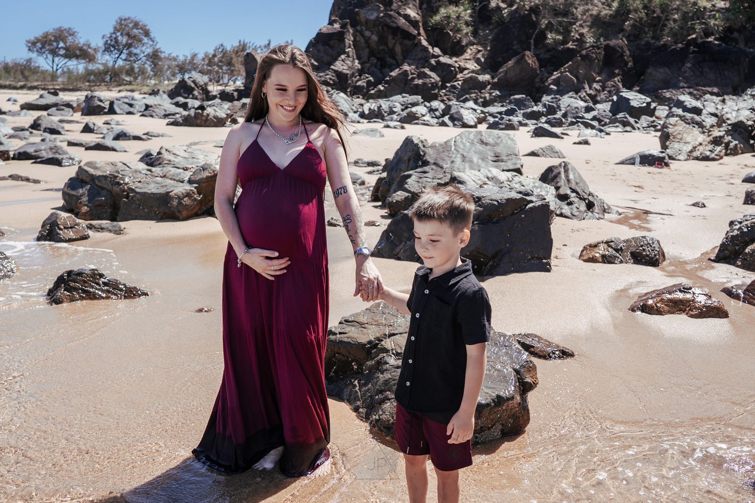Family enjoying a sunny day exploring tide pools and rocky beach formations along a scenic coastline.