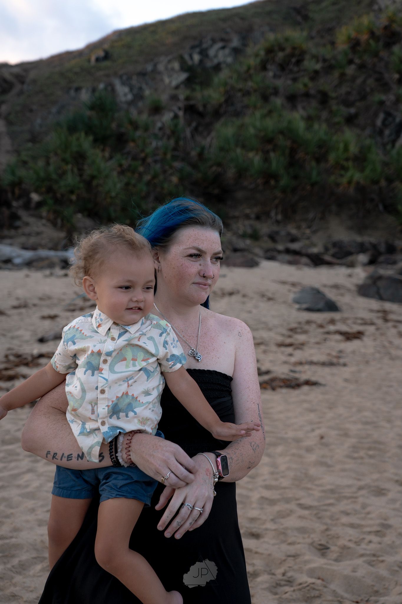 Four sequential photos show a tender moment between parent and child against a rocky beach landscape at sunset.