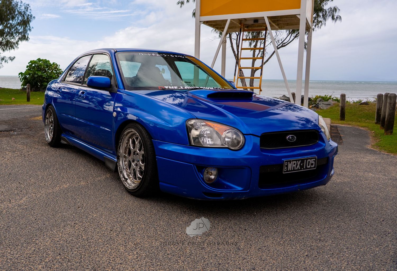 Bright blue Subaru WRX STI showcased in multiple angles on a cloudy day showing its distinctive sporty design.
