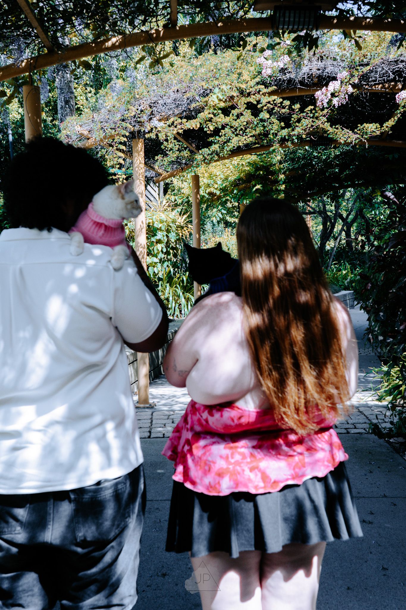 A sequence of photos showing someone hugging a large white plush character mascot in a garden setting.