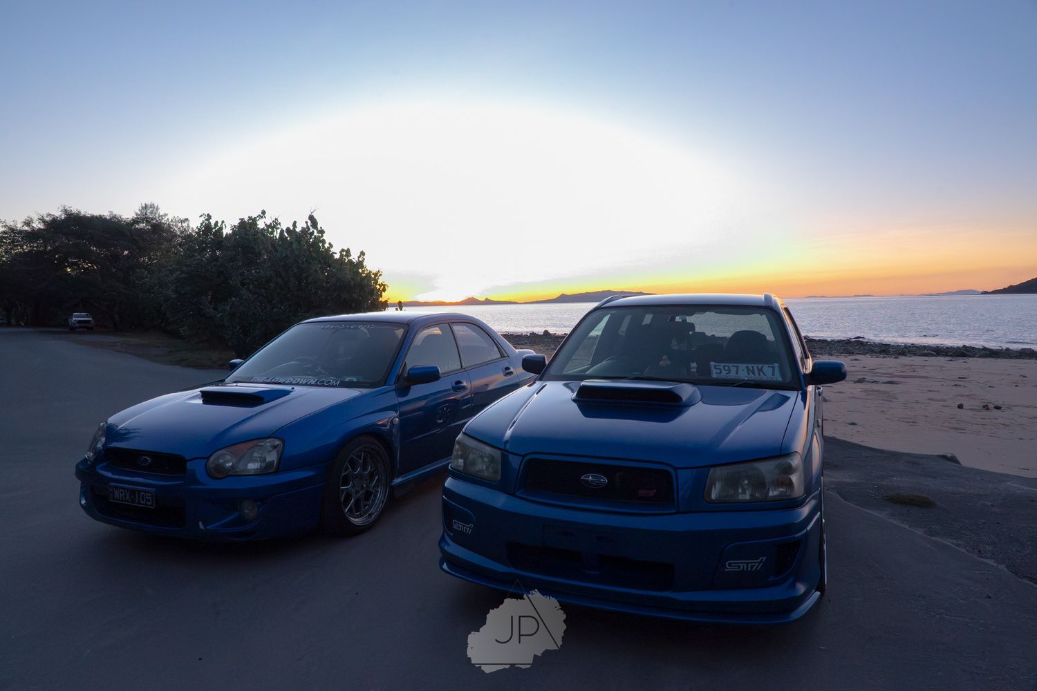 Blue Subaru Impreza WRX cars parked at sunset showing multiple angles of the same modified performance vehicle.