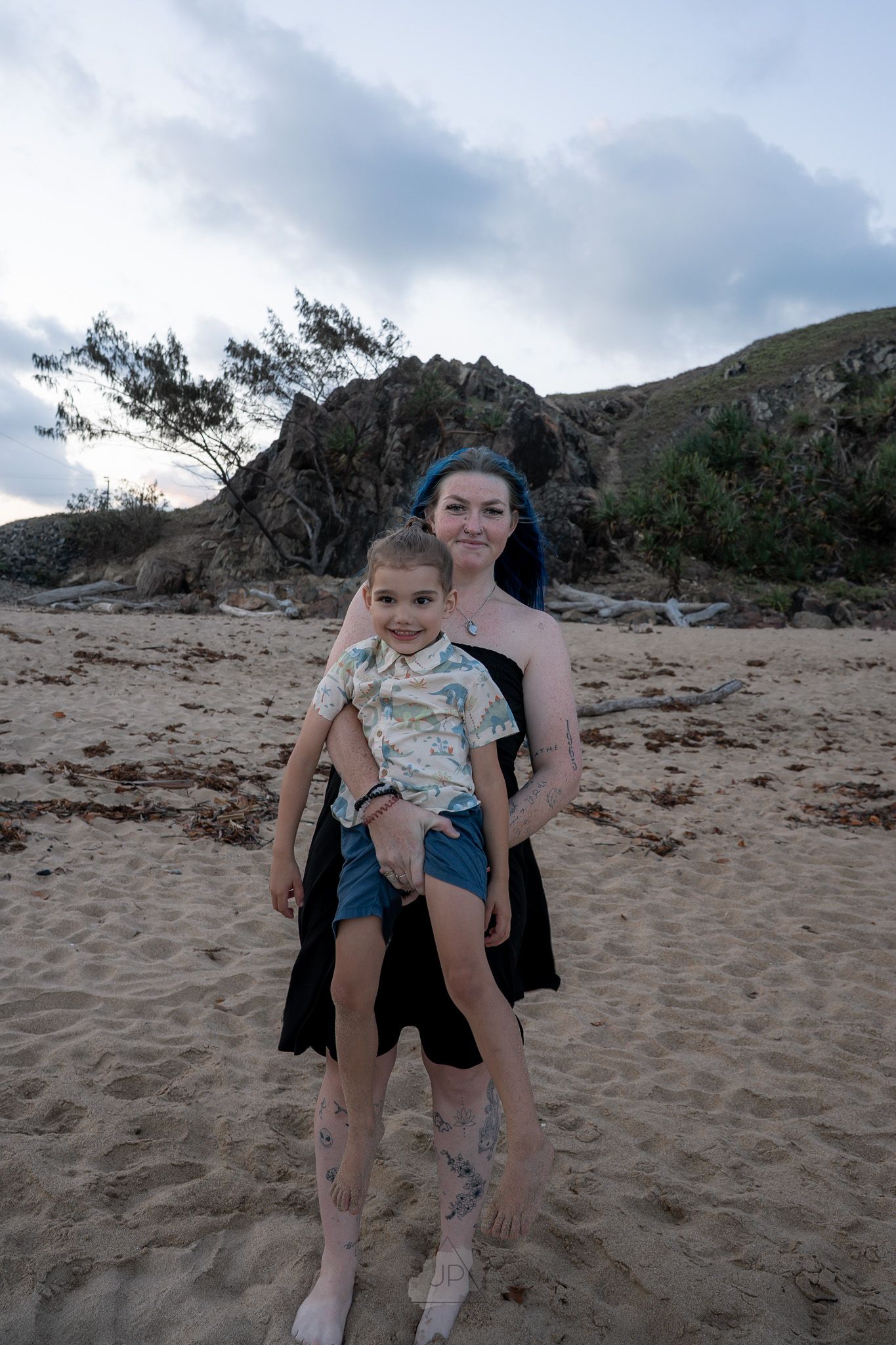 Three sequential photos show a playful moment on a sandy beach with windswept trees in the background.
