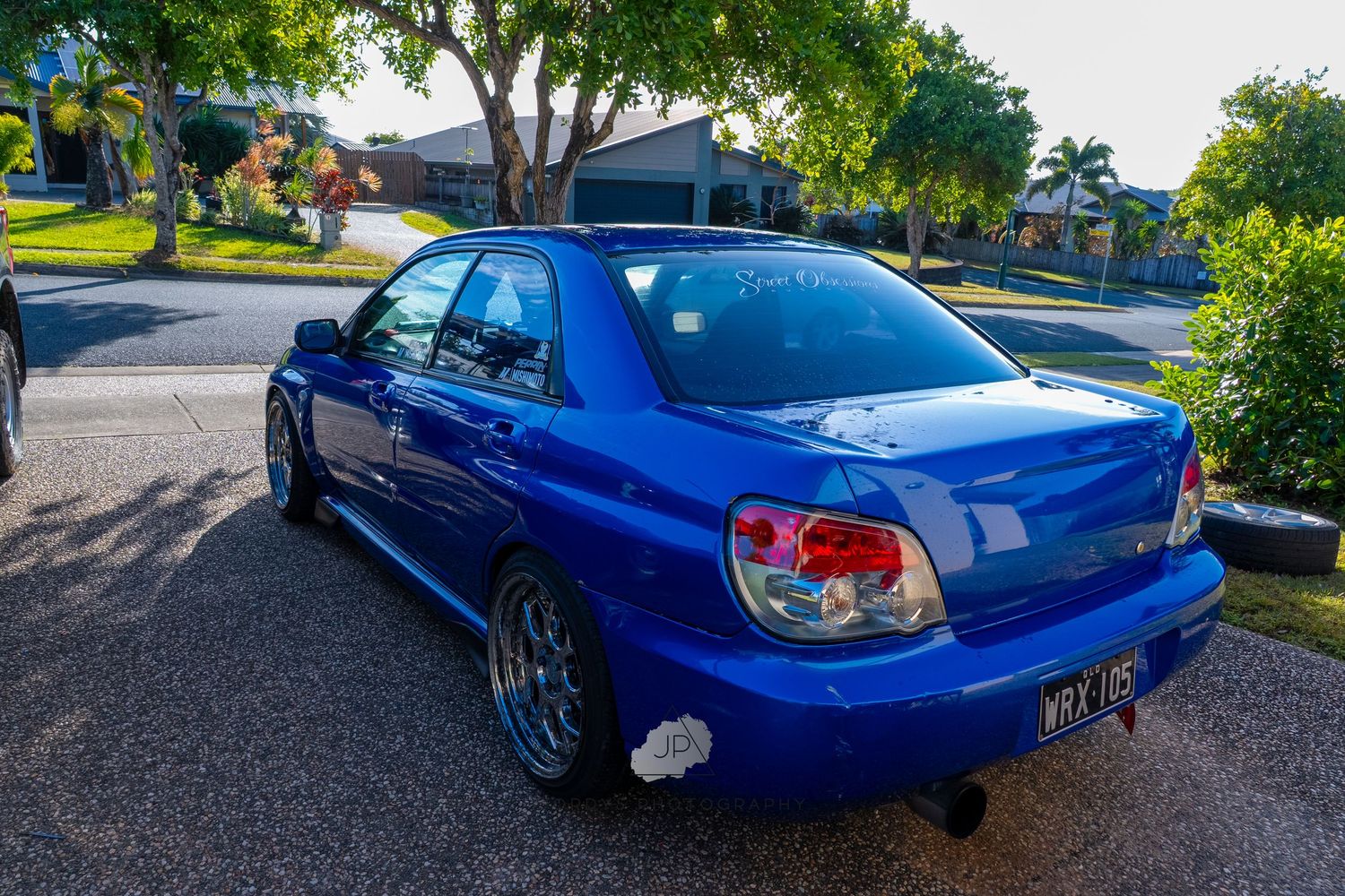 Series of blue Subaru WRX angles showing custom modifications and sporty styling against suburban backdrop.