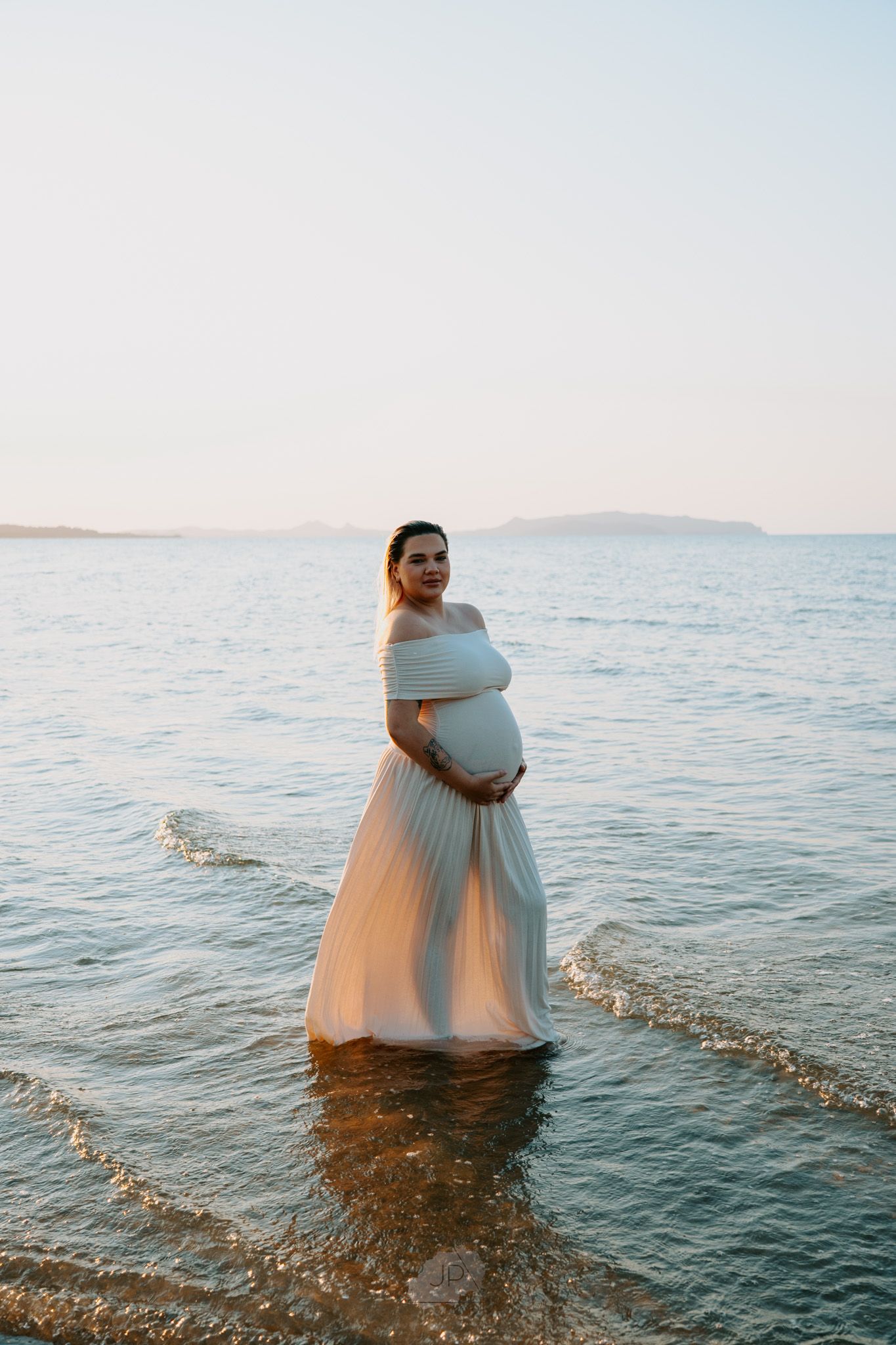 Three sequential photos show a person in a flowing white dress standing in shallow ocean water at sunset.