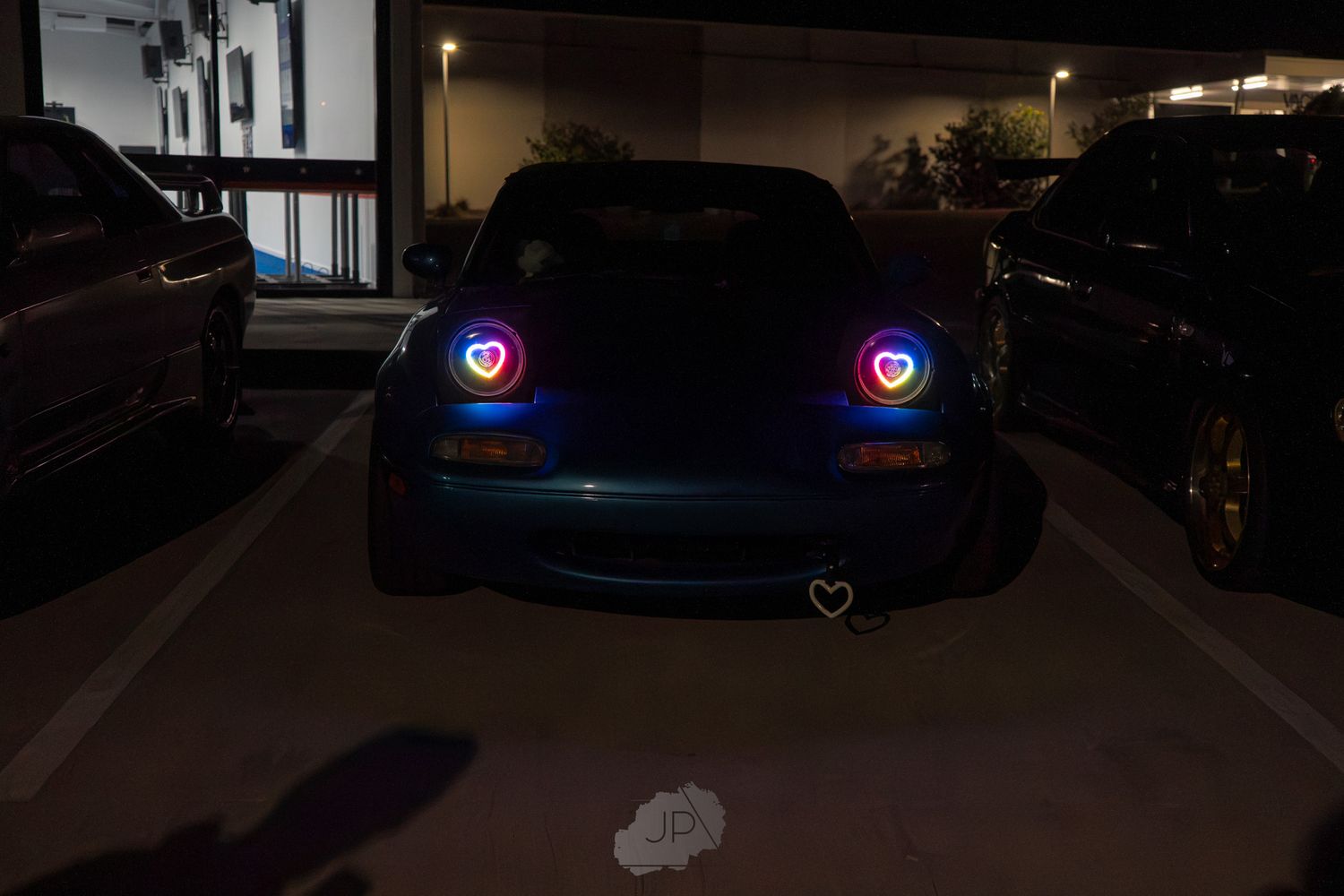 A BMW M3 vehicle parked at night with glowing LED headlights creating an atmospheric scene.