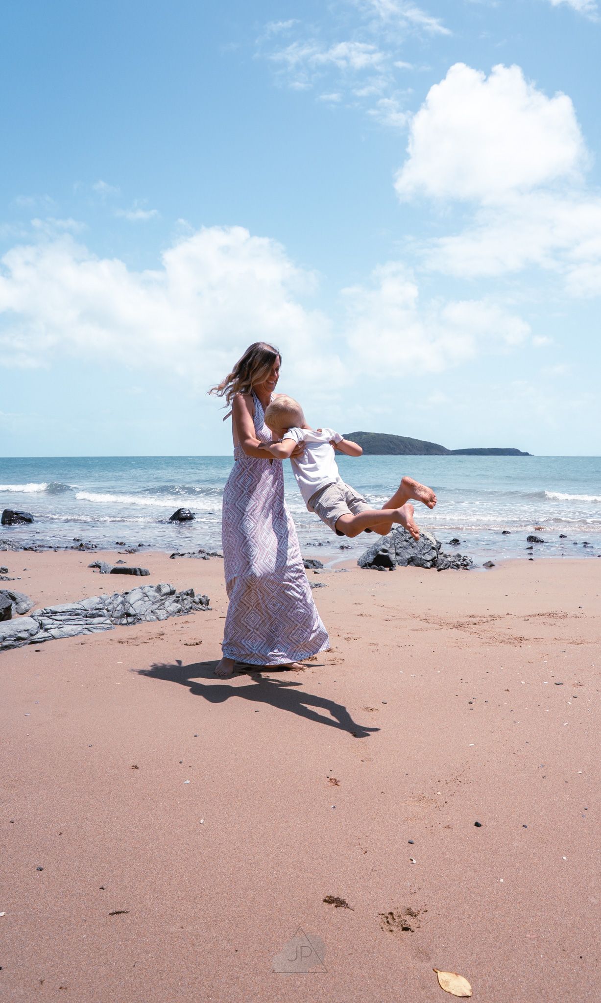 A sequence of photos showing someone in a white dress twirling and dancing on a sandy beach with ocean waves in the background.