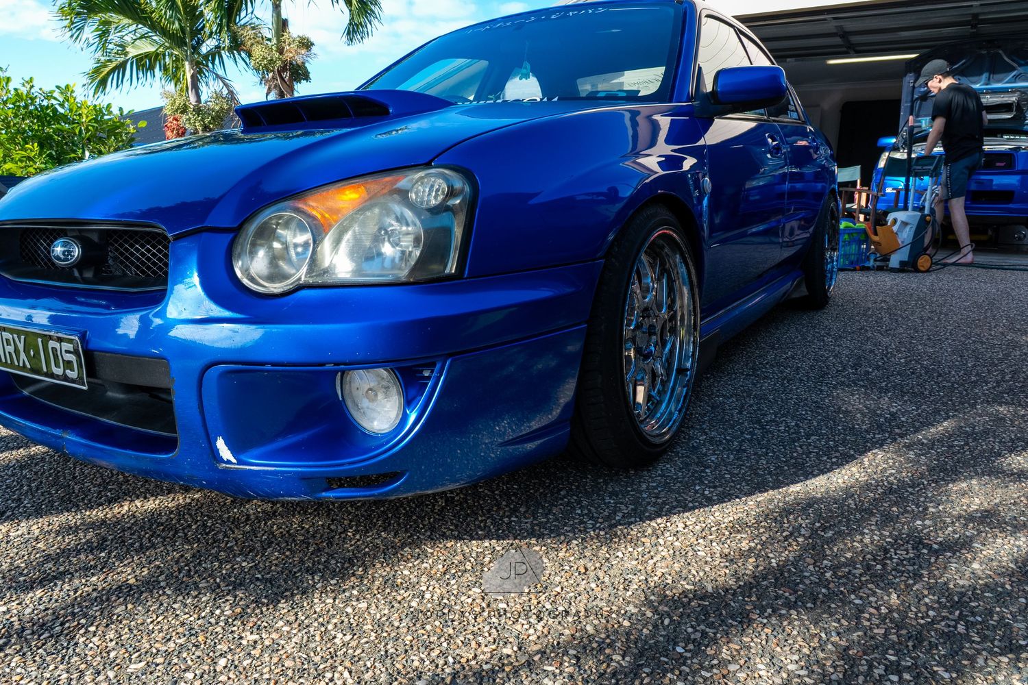 Blue Subaru Impreza WRX with gold wheels and aftermarket modifications shown from multiple angles in sunny setting.