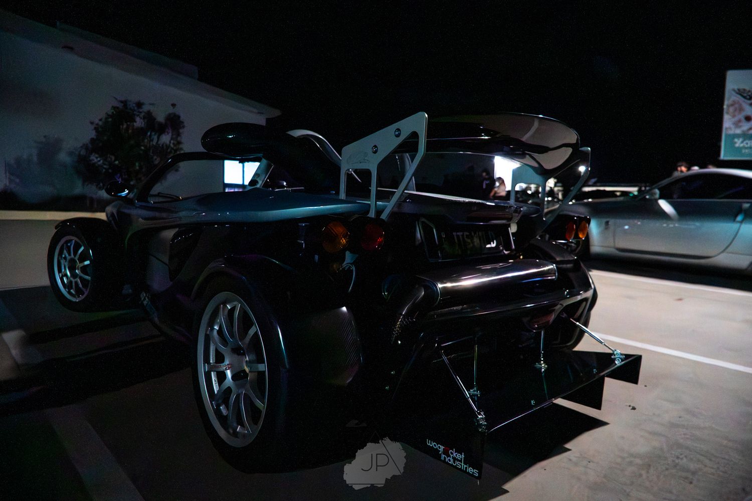 Rear view silhouette of a luxury sports car in low light conditions highlighting its athletic profile.