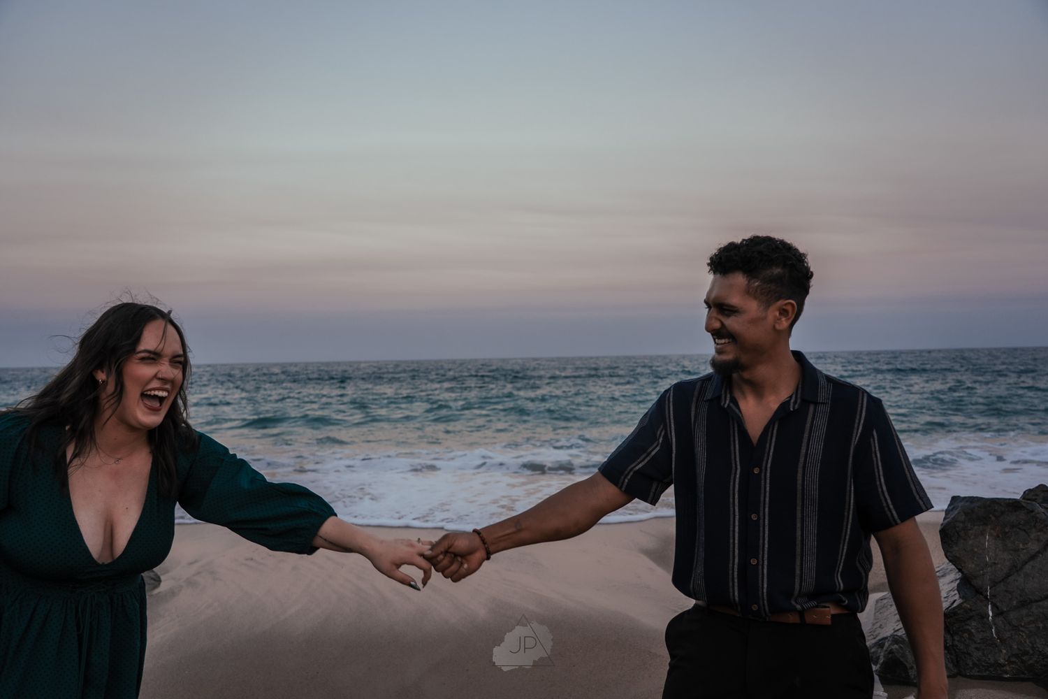 A series of romantic beach photos showing a couple walking and embracing along a misty oceanfront at sunset.