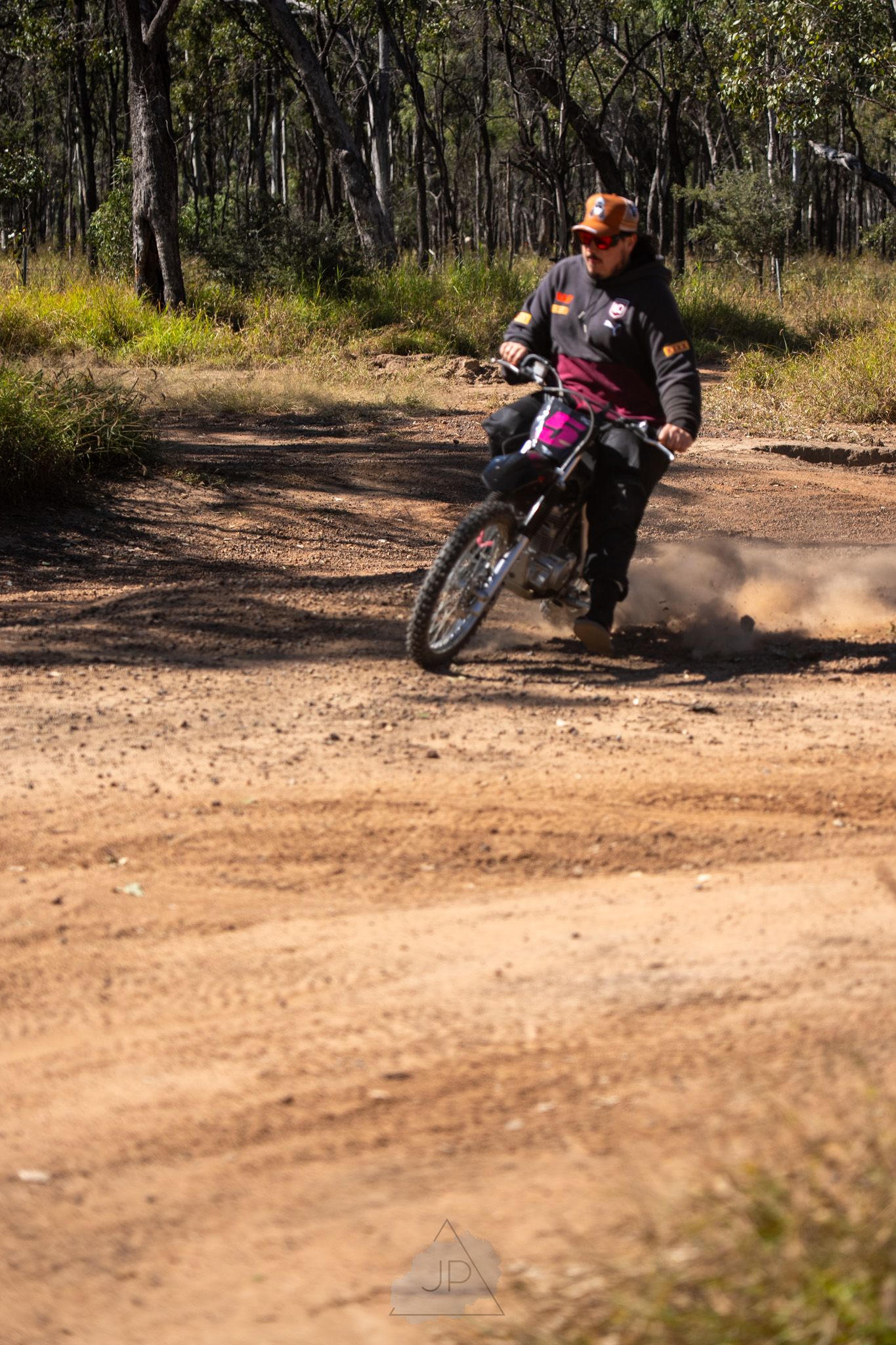 Motorcycle rider sliding through a dirt corner on a forest trail in a dynamic sequence of action shots.